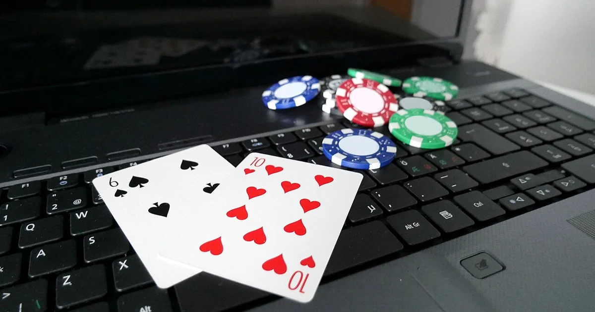 Laptop with poker cards and poker chips.